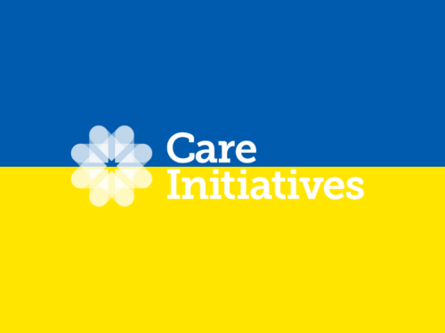 A two-toned background features blue on the top half and yellow on the bottom half. At the center of this background, there is a white geometric flower design. Below or alongside this design, the words 