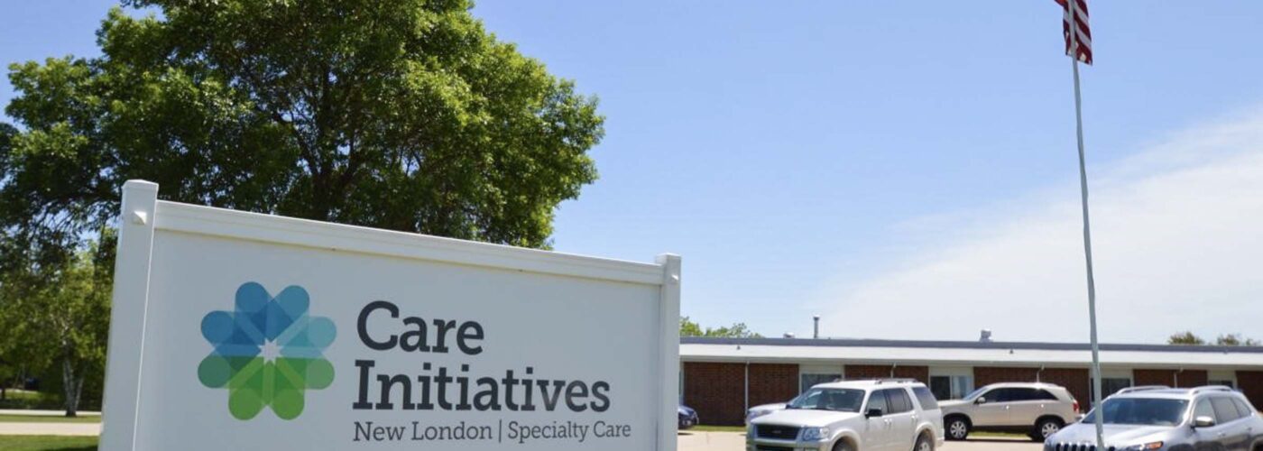 Care Initiatives New London Specialty Care  
100 Care Circle Street  
Care Initiative  

[Background: Building with parked cars, an American flag on a pole, tree under clear blue sky].